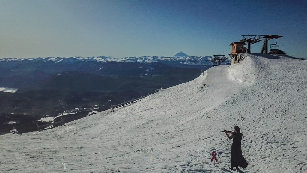 Una violinista en le cumbre del Cerro Teta a casi 2000m de altura. Mirá la Campaña #JuntosAlTeta 2022 que realizó Chapelco para concientizar sobre la detección temprana del cáncer de&nbsp;mama.